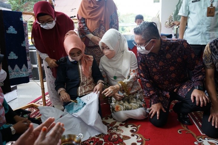 Direktur Utama PT Pertamina (Persero) Nicke Widyawati (duduk, kiri) belajar membatik ketika berkunjung ke Sentra Budaya dan Ekonomi Kreatif Melayu Riau di Pekanbaru, Riau, pada Kamis (30/12).