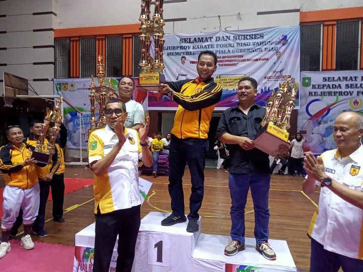 Ketua Forki Riau Parisman Ihwan menyerahkan piala bergilir gubernur Riau kepada Forki Pekanbaru yang berhasil meraih juara umum Kejurprov Forki Riau di GOR Tribuana Pekanbaru