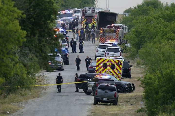Foto : Polisi bekerja di tempat kejadian di mana puluhan orang ditemukan tewas di sebuah semitrailer di daerah terpencil di barat daya San Antonio pada 27 Juni 2022. 