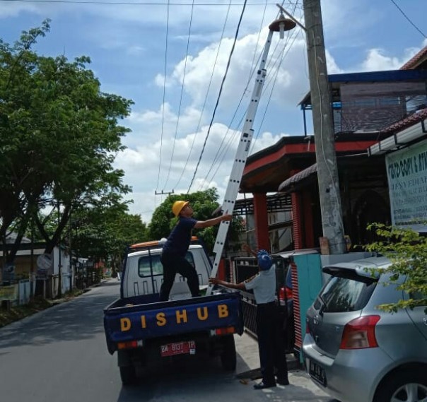 Petugas Dishub Pekanbaru menganti lampu PJU yang tidak sesuai aturan (foto/istimewa) 