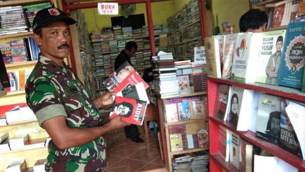 Personil TNI memagang buku tentang PKI (foto/int) 