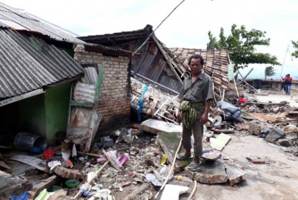 Salah seorang warga Lampung berada di antara puing-puing rumah yang rusak berat akibat diterjang tsunami, akhir Desember 2018 lalu. Foto: int 