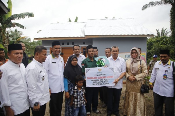 Drs H Syamsuar MSi menyerahkan secara simbolis bantuan Rumah Layak Huni (RLH) yang disalurkan  BAZNAS Kabupaten Siak/lin