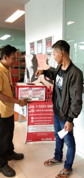 Konsumen mengambil kopun hadiah program Honda CDN