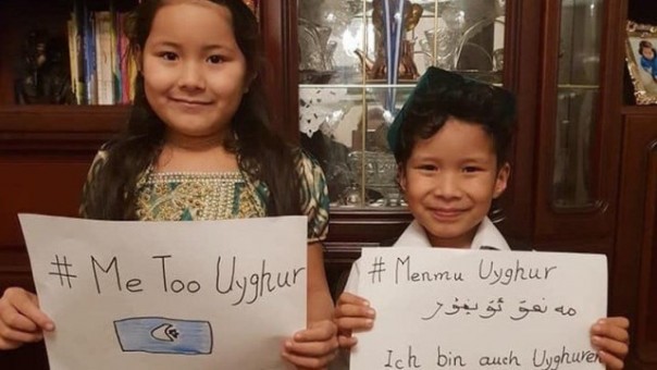 Dua bocah Uighur memperlihatkan tagar #MeTooUyghur. Tagar ini marak di Twitter dan Facebook yang isinya mendesak pemerintah China menunjukkan kondisi keluarga mereka yang masih ditahan di kamp Xinjiang. Foto: int 
