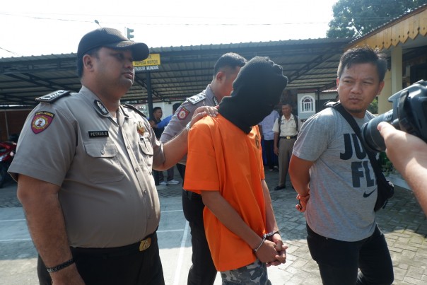 Salah satu pelaku pengeroyokan berinisial MIN saat digiring petugas Polsek Limapuluh. Foto. (Riau24/amri)
