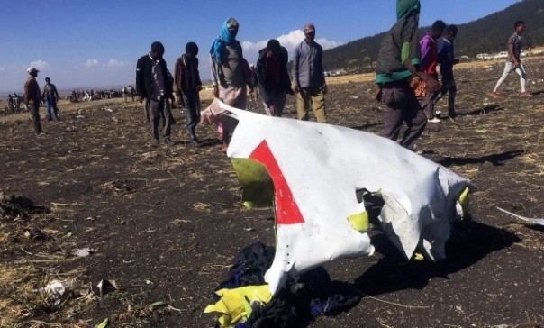 Warga menelurusi lokasi jatuhnya pesawat Ethiopian Airlines dekat Bandara Addis Ababa, Ethiopia. Tampak salah satu kepingan pesawat yang hancur. Foto: int 