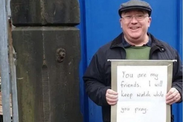Andrew Graystone, berdiri di depan Masjid Madina Manchester, Inggris, sambil membawa poster berisi dukungannya terhadap kaum muslim. Foto: int 