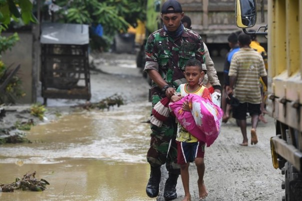 Prajurit TNI mengawasi seorang bocah Sentani, Papua, yang terpaksa mengungsi setelah rumahnya rusak dihantam banjir bandang. Foto: int 