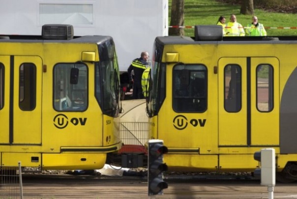 Mayat salah satu korban tewas tampak ditutup kain putih di sela-sela trem yang menjadi tempat terjadinya aksi penembakan brutal di Utrecht, Belanda. Foto: int 
