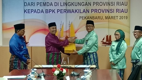 Gubernur Riau, Syamsuar saat menyerahkan LKPD Riau 2018 ke Kepala BPK Perwakilan Provinsi Riau Thomas Ipoeng Anjar Wasito 