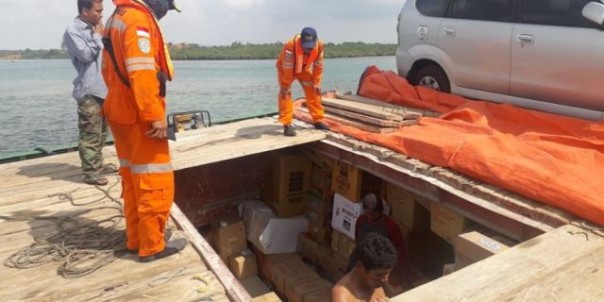 Petugas menjaga ketat kapal pembawa logistik Pemilu untuk Kabupaten Natuna, yang kandas di perairan Bintan, Provinsi Kepulauan Riau. Foto: int 