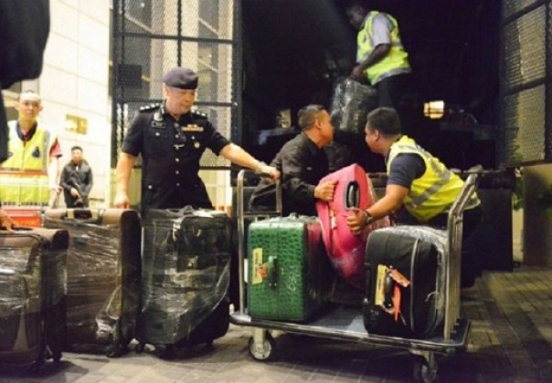 Sejumlah petugasmembawa barang-barang yang disita dari kediaman Najib Razak, beberapa waktu lalu. Foto: int 