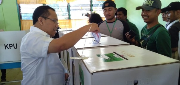 Bupati,  Drs H Irwan MSi memasukkan surat suara saat menggunakan hak pilihnya di TPS 6 Desa Banglas/mad