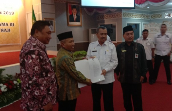 Gubernur Riau, Syamsuar saat menerima SK Kemenag Embarkasi Haji Antara yang diserahkan oleh Dirjen PHU Nizar