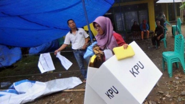Petugas salah satu TPS yang menggelar PSU di Kota Padang, terpaksa harus menyelematkan peralatan pemungutan suara saat badai melanda kota itu. Foto: int 