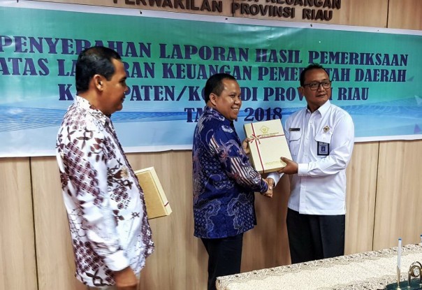 Disaksikan Wakil Ketua DPRD, DR M Taufikurrohman, Bupati Kepulauan Meranti, Drs H Irwan MSi menerima LHP-LKPD dari Kepala BPK RI Wilayah Riau, T Ipoeng Andjar Wasita/DV