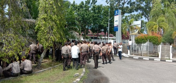 Pihak kepolisian saat menjaga gerbang masuk ke gedung KPU Riau