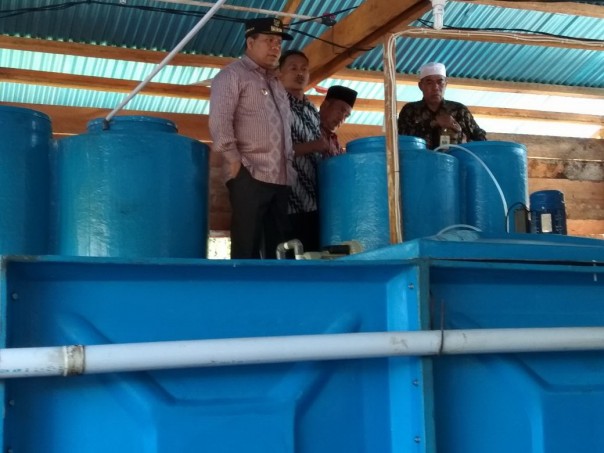 Bupati,  Drs H Irwan MSi bersama Sutrisno melihat kapasitas air bersih dalam tanki di Desa Kundur,  Kecamatan Tebingtinggi Barat belum lama ini/ADV