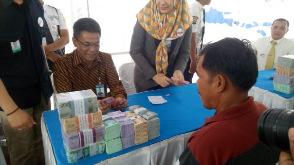 Kepala BI Perwakilan Riau, Decymus saat memberikan penukaran uang kepada masyarakat
