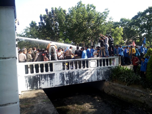 Polisi menyiram mahasiswa dengan mobil watercanon di depan kantor DPRD Riau
