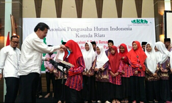 Ketua Komda APHI Komda Riau Muller Tampubolon, SE, MM bagikan santunan anak yatim (foto/riki)