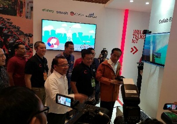 Direktur Utama Telkomsel Ririek Adriansyah (tengah) bersama Presiden RI Joko Widodo saat mengunjungi booth Telkomsel Experience Zone/ist