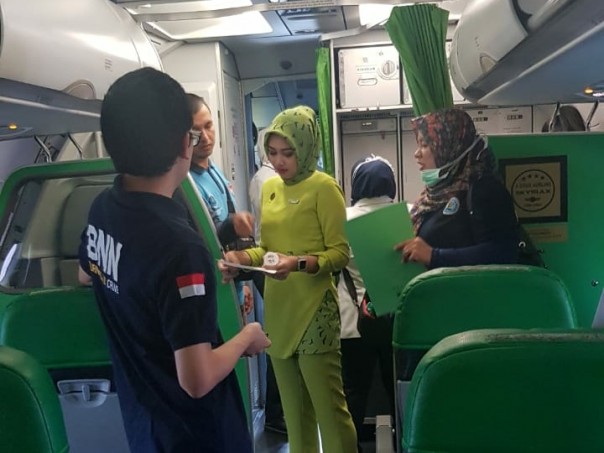 Petugas BNNP Riau tengah melakukan tes urin terhadap pramugari dan Pilot didalam pesawat. 