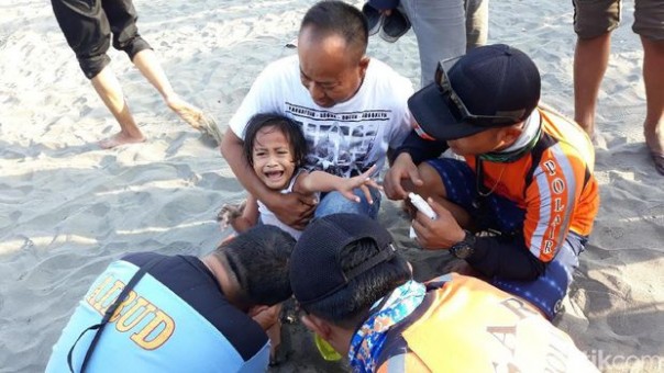 Petugas medis saat memberikan pengobatan ketika wisatawan terkena ubur-ubur. (Foto: Detik.com)
