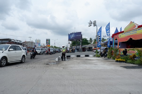 Tampak seorang petugas Satlantas Polresta mengatur kendaraan melintas di Simpang Jalan Garuda Sakti-HR Soebrantas, jalur ini diprediksi akan padat pada saat arus balik dua hari mendatang.