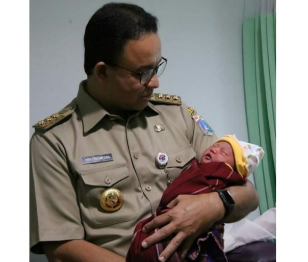 Gubernur Anies Baswedan mengendong bayi saat inspeksi Puskesmas (foto/int)