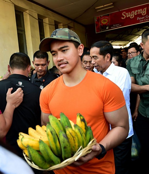 Kaesang membawa pisang usai berbelanja di pasar bersama Presiden Jokowi di Solo (foto/int)