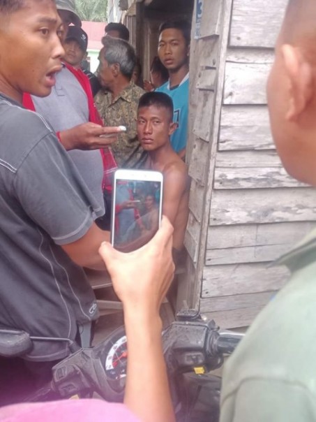 Bobi yang sudah babak belur, diamankan di salah satu rumah warga sebelum diserahkan ke Mapolsek Bagan Sinembah, Rokan Hilir, Riau. Foto: amr 