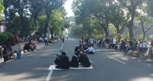 Sejumlah peserta aksi duduk-duduk di Jalan Merdeka Barat, berdekatan dengan Gedung MK. Foto: int 