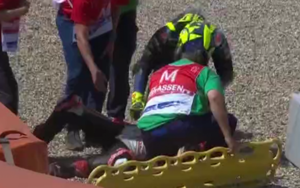 Pembalap Valentino Rossi menghampiri petugas medis yang sedang menangani Nakagami usai mangalami Crash di lap kelima.