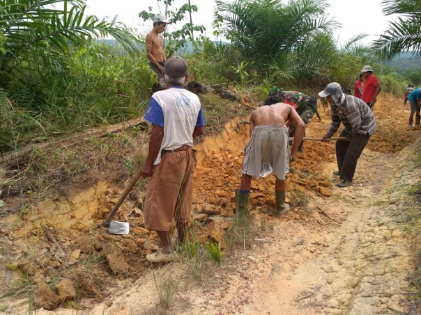 Babinsa Koramil 14/Kepenuhan Kodim 0313/KPR, Serda Hariyanto bersama masyarakat, melakukan pengecoran jalan setapak yang terletak di Desa Muara Jaya