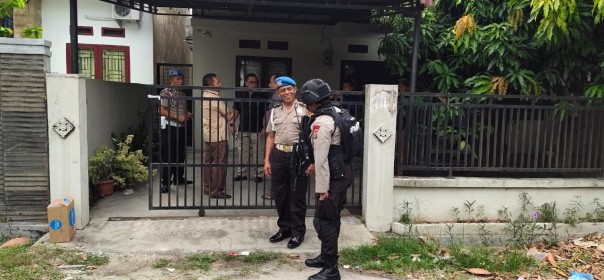 Pihak kepolisian saat berjaga di rumah penjahat kakap Satriandi di Pekanbaru