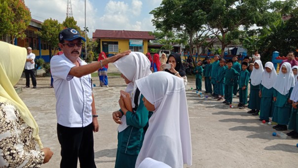 Sekretaris Kesbangpol Kabupaten Inhil Marlis Syarif menyerahkan bantuan kepada siswa/rgo