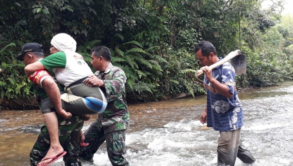 Satgas TNI Bantu Seberangi Anak SD dan Orang Sakit di Desa Balung (foto/int)