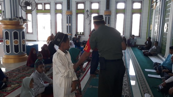 Anggota Babinsa Koramil 14/Kepenuhan Sertu Irwan Bersama Pengurua Mesjid Baiturrahman Beri Sanrunan ke Anak Yatim (foto/int)