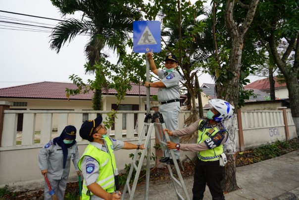 Kepala Jasa Raharja Cabang Riau, Herry Kesuma saat melakukan giat pembersihan rambu lalu lintas dalam rangka peringati HUT Riau ke 74