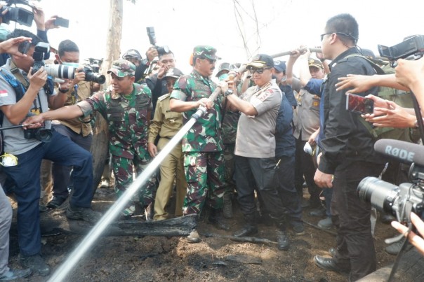 Kapolri Tito dan Panglima TNI Hadi melakukan penyiraman ke lahan bekas terjadinya Karhutla (foto/int)