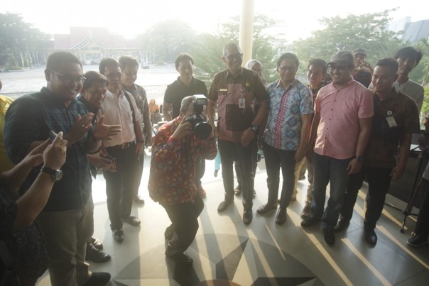 Gubernur Riau H Syamsuar berpose memegang kamera saat membuka pameran foto PFI 