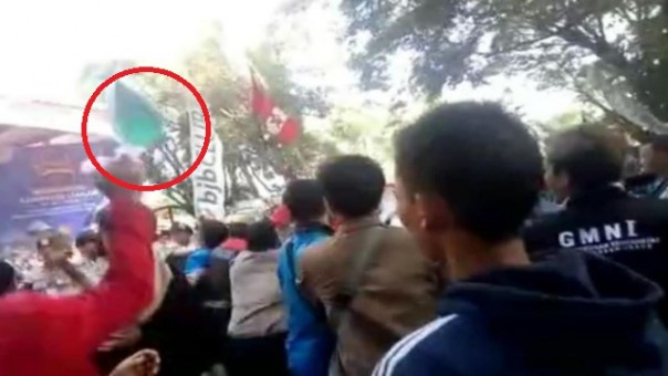 Rekaman yang memperlihatkan bungkusan berwarna biru dilemparkan seorang pria berjas merah ke arah kerumunan mahasiswa dan polisi, saat terjadi aksi demonstras di Cianjur. Foto: int 