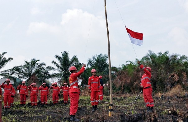 Personil Manggala Agni Pekanbaru tengah menaikkan bendera Merah Putih