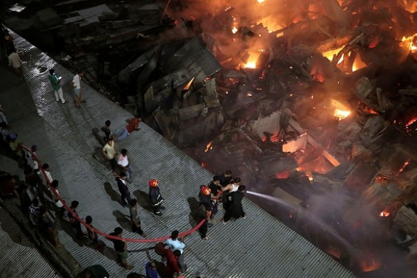 Petugas berusaha memadamkan api yang membakar kawasan pemukiman di Dhaka, Bangladesh. Foto: int 