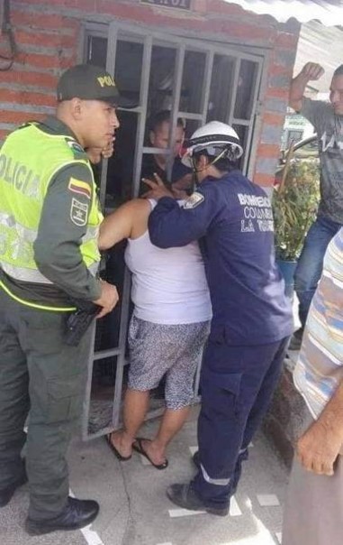 Petugas pemadam kebakaran berusaha mengeluarkan kepala seorang wanita di Kolombia dari jeruji pintu (foto/int)