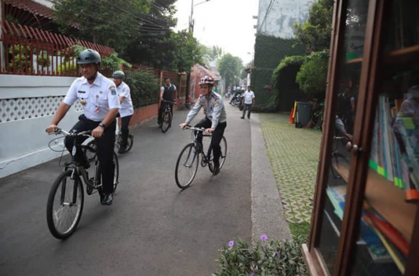 Gubernur DKI Jakarta, Anies Baswedan saat ditemani oleh Kepala Dinas Bina Marga DKI Jakarta, Hari Nugroho dan Kepala Dinad Perhubungan DKI Jakarta, Syafrin Liputo menggunakan sepeda ke Balaikota