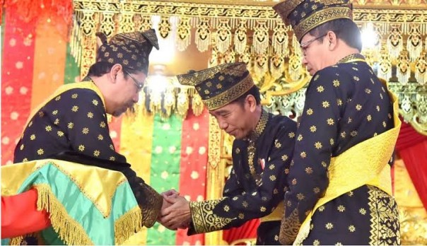 Presiden Jokowi saat menerima gelar Datu Seri Setia Amanah Negara dari Lembaga Adat Melayu (LAM) Riau