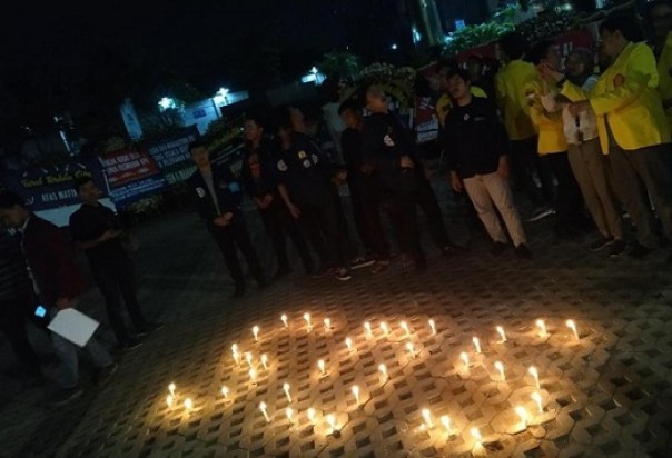 Puluhan lilin menyala membentuk kata SOS di depan Gedung KPK. Foto: int 